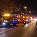 Vehicles in parade looking down street